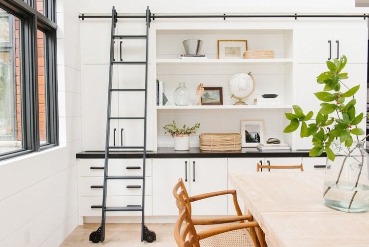 Cette image montre une grande salle à manger ouverte sur la cuisine minimaliste avec un mur blanc, parquet clair et aucune cheminée.