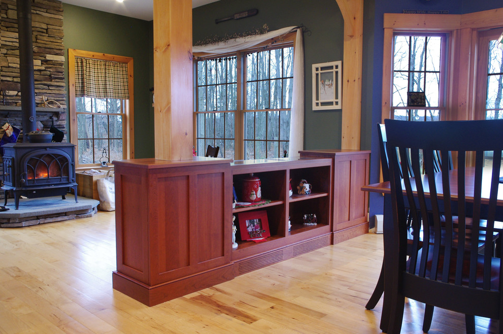 Idée de décoration pour une salle à manger ouverte sur le salon craftsman de taille moyenne avec parquet clair et un poêle à bois.