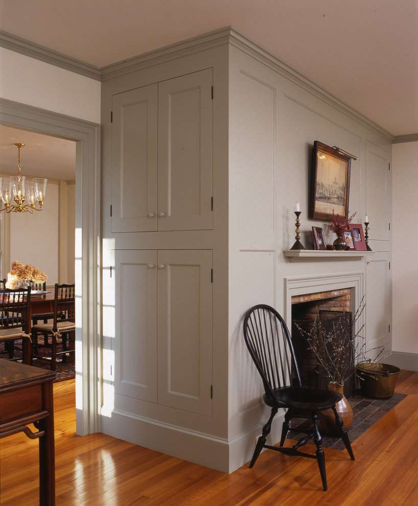 Inspiration for a timeless medium tone wood floor kitchen/dining room combo remodel in Boston with white walls, a standard fireplace and a brick fireplace