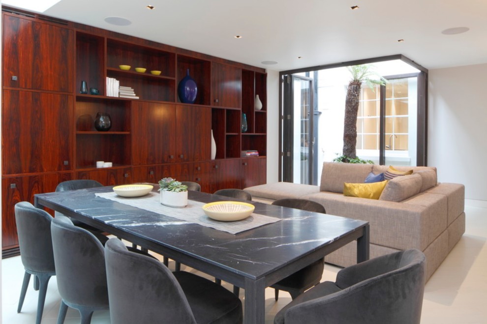 This is an example of a medium sized contemporary dining room in London with grey walls and white floors.