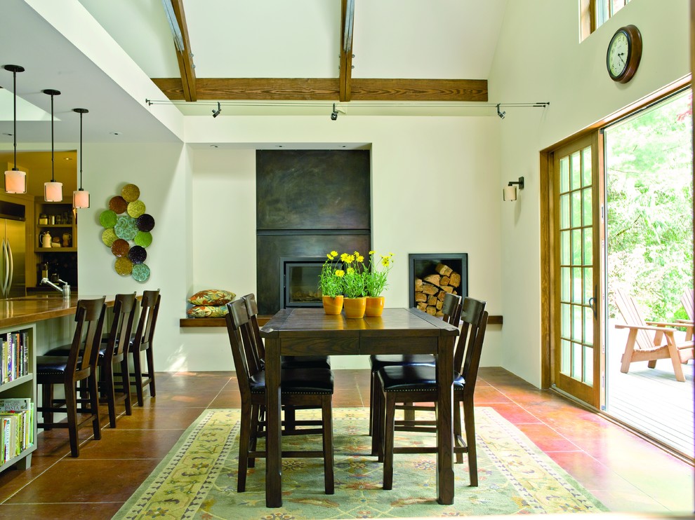 На фото: кухня-столовая среднего размера в классическом стиле с бетонным полом, белыми стенами, стандартным камином, фасадом камина из бетона и коричневым полом