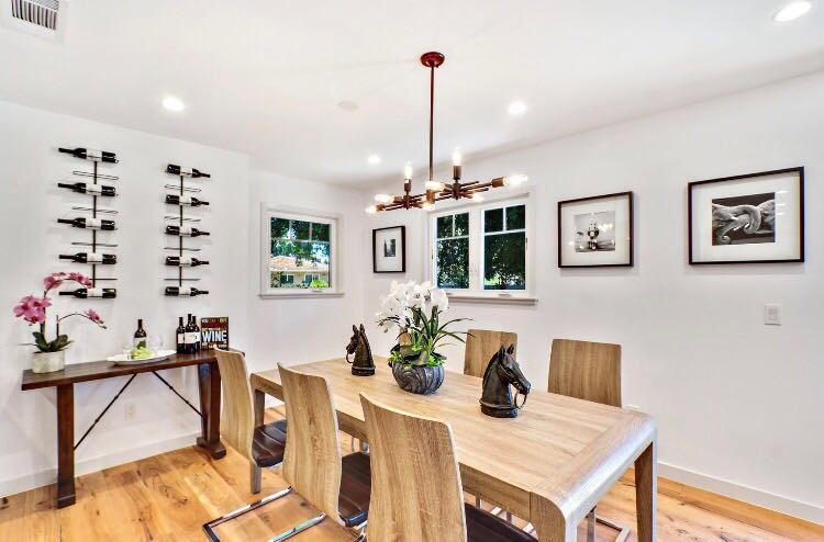 Cette photo montre une salle à manger ouverte sur la cuisine chic de taille moyenne avec un mur blanc, parquet clair, aucune cheminée et un sol beige.