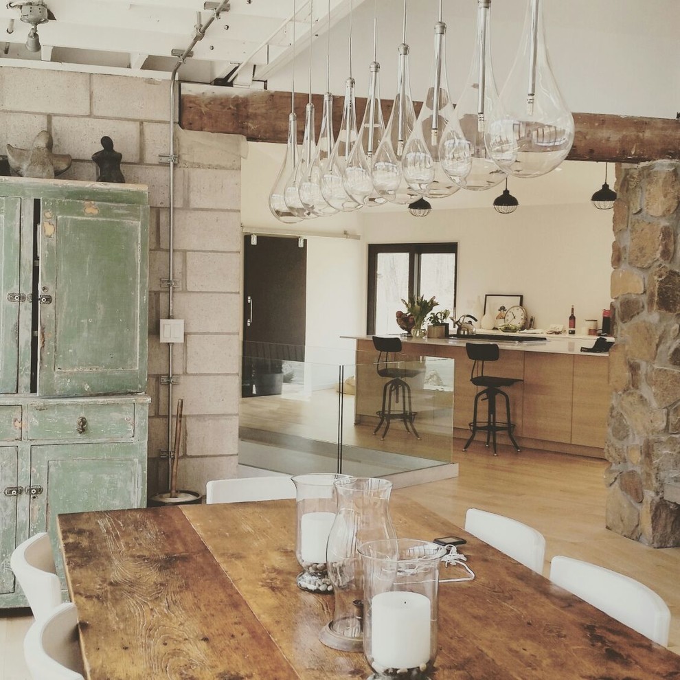 Идея дизайна: большая кухня-столовая в стиле кантри с белыми стенами, светлым паркетным полом и фасадом камина из камня