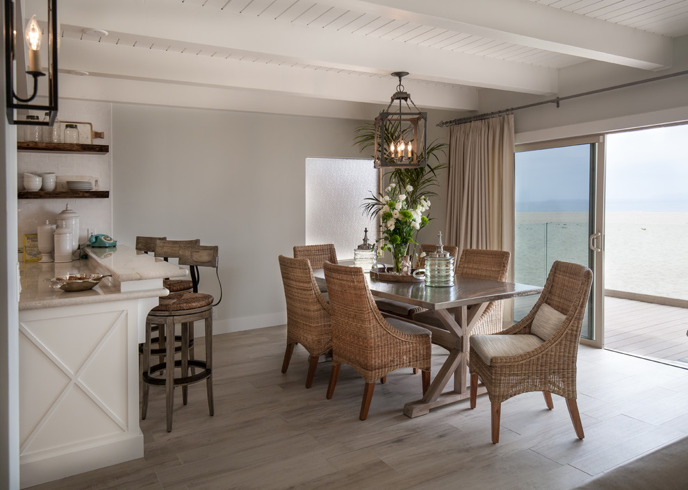 Cette image montre une salle à manger ouverte sur la cuisine marine de taille moyenne avec un sol en carrelage de porcelaine et un mur gris.