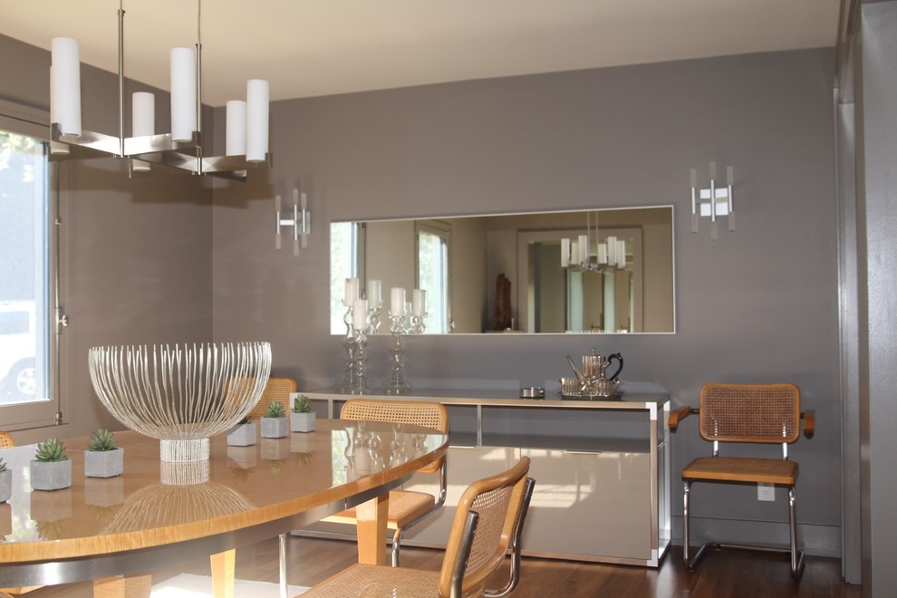 Ispirazione per una sala da pranzo aperta verso la cucina minimal di medie dimensioni con pareti grigie, pavimento in legno massello medio e nessun camino