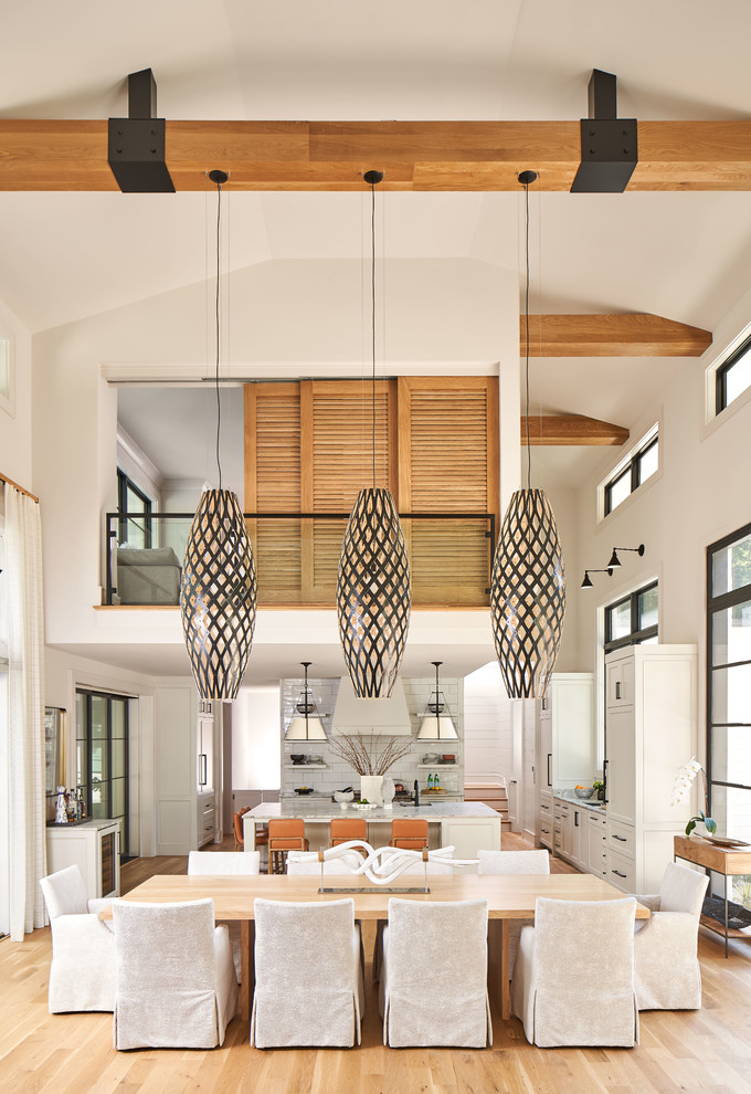 Idée de décoration pour une salle à manger ouverte sur la cuisine tradition avec un mur blanc, un sol en bois brun et un sol marron.