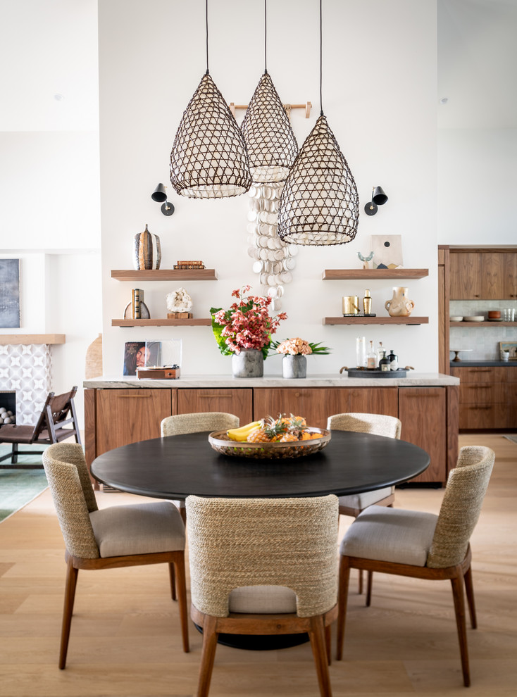 Inspiration for a mediterranean open plan dining room in Orange County with white walls, light hardwood flooring and no fireplace.