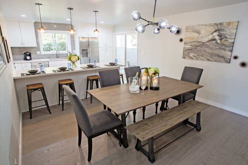 Immagine di una sala da pranzo aperta verso la cucina minimal di medie dimensioni con pareti grigie, pavimento in laminato e pavimento grigio