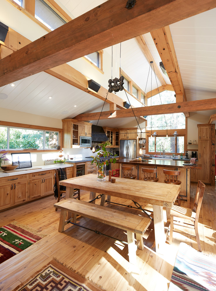 Foto di una grande sala da pranzo aperta verso la cucina stile rurale con pareti beige e pavimento in legno massello medio