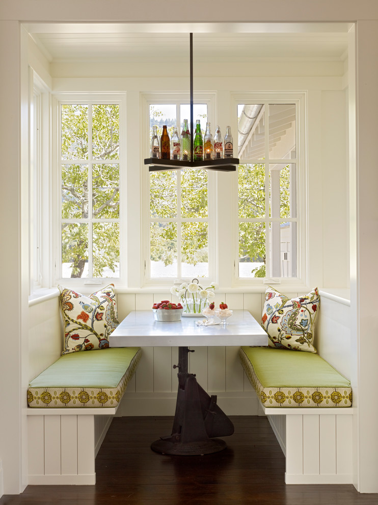 Cette image montre une salle à manger rustique avec un mur blanc et parquet foncé.