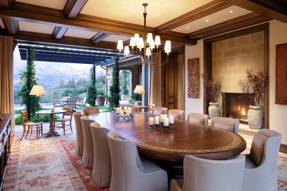 Design ideas for a mediterranean dining room in Other with a standard fireplace and a stone fireplace surround.