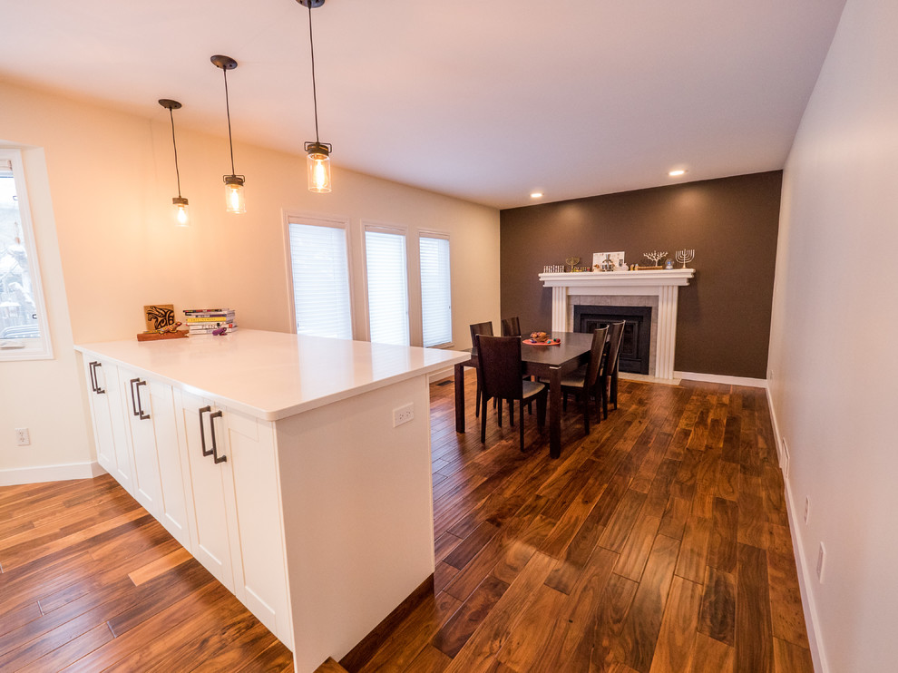 Cette photo montre une salle à manger ouverte sur la cuisine chic de taille moyenne avec un mur beige, un sol en bois brun, aucune cheminée et un sol marron.