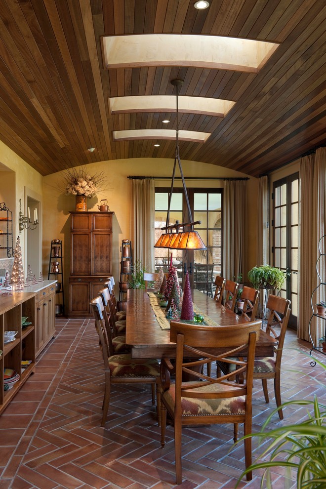 Ispirazione per una sala da pranzo classica con pavimento in mattoni e pareti gialle