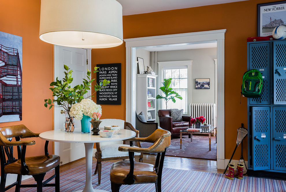 Great room - mid-sized traditional medium tone wood floor great room idea in Boston with orange walls