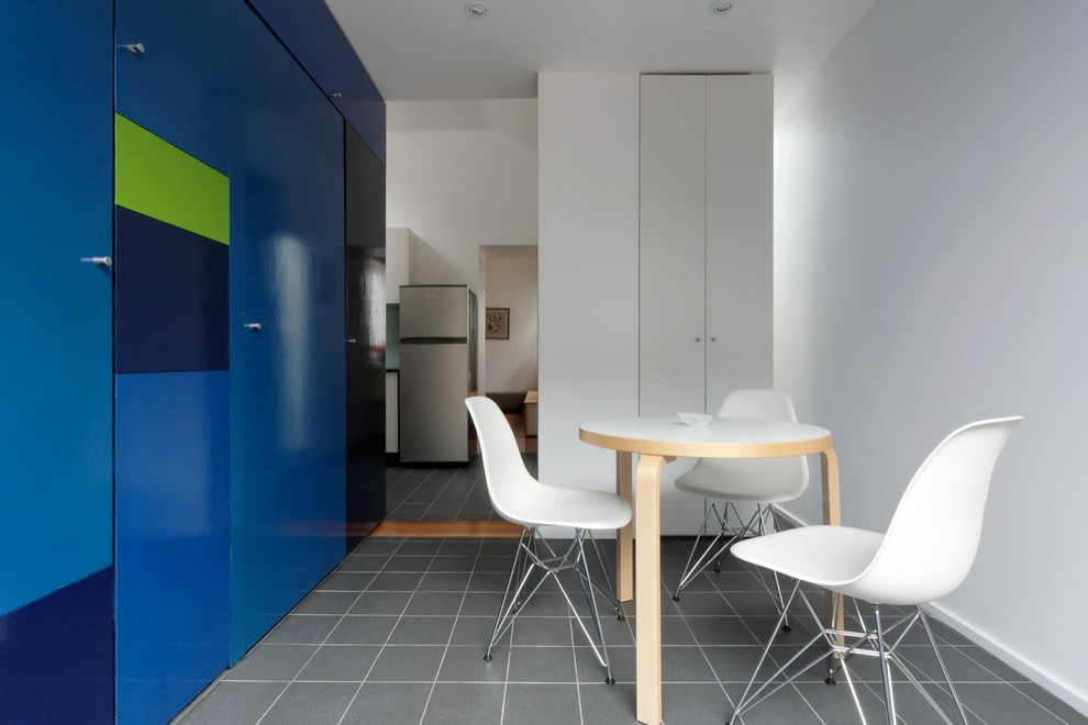 Пример оригинального дизайна: столовая в современном стиле с синими стенами и полом из керамической плитки