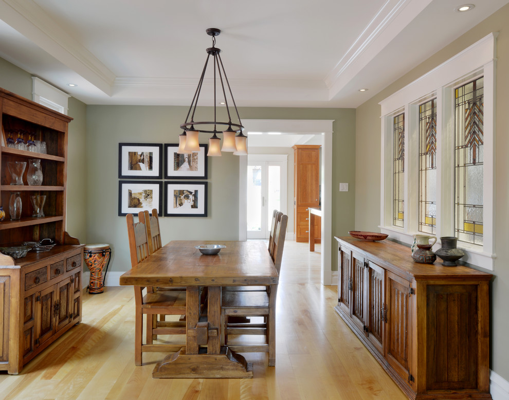 Example of a classic medium tone wood floor dining room design in Toronto with green walls
