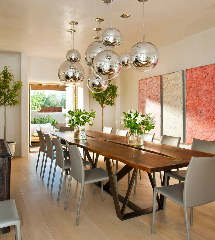 Exemple d'une salle à manger ouverte sur la cuisine sud-ouest américain avec un mur blanc et un sol en bois brun.
