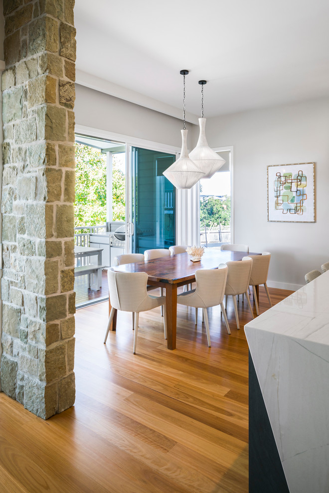 Idées déco pour une salle à manger ouverte sur la cuisine contemporaine avec un mur gris, un sol en bois brun et un sol marron.