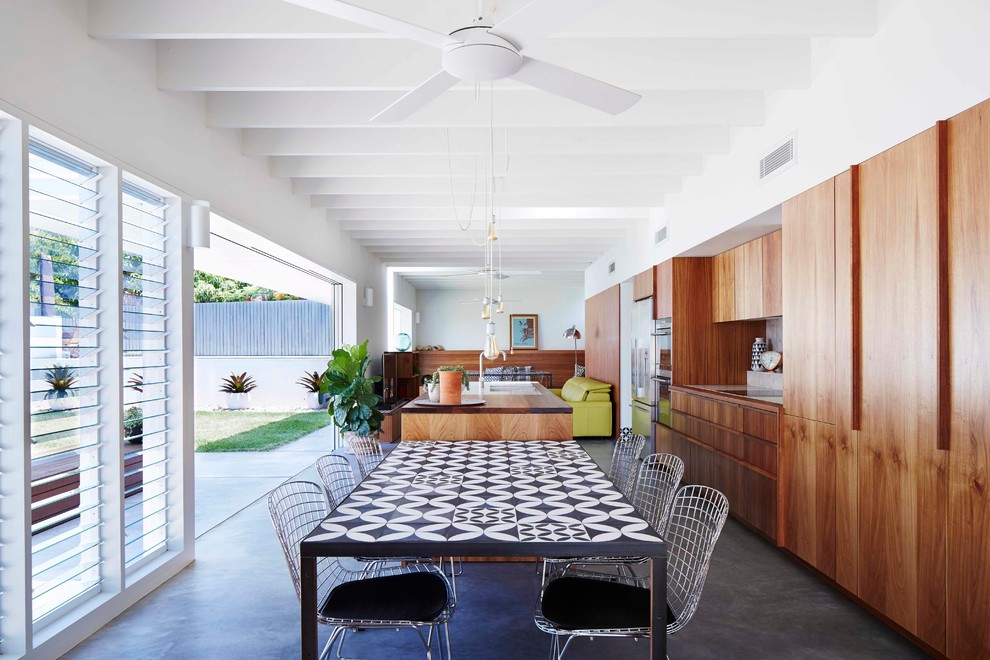 Idée de décoration pour une salle à manger ouverte sur le salon minimaliste de taille moyenne avec un mur blanc et sol en béton ciré.