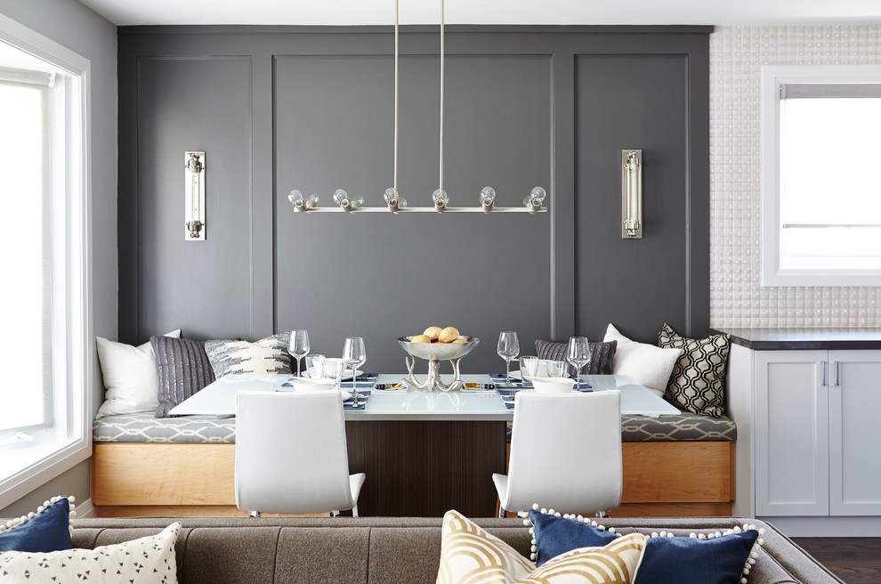 Réalisation d'une salle à manger ouverte sur la cuisine design avec un mur gris et un sol en bois brun.