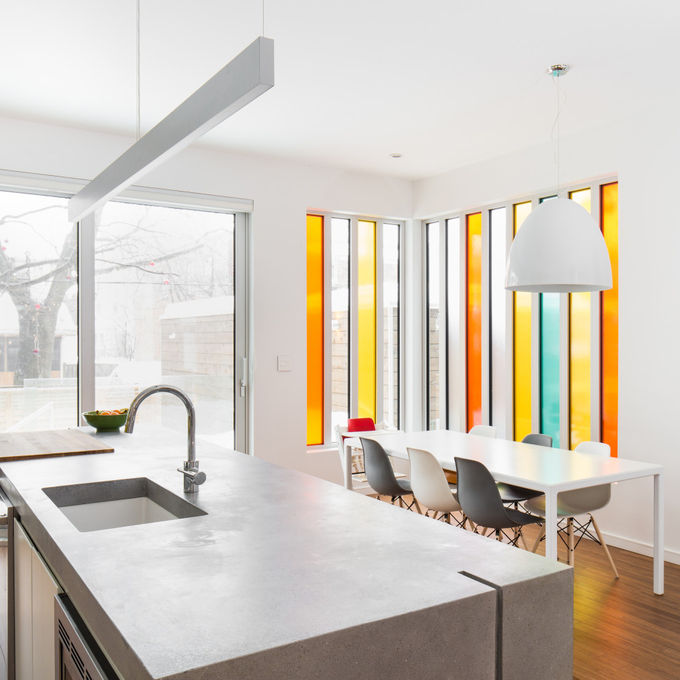 Esempio di una sala da pranzo aperta verso la cucina contemporanea con pareti bianche, pavimento in legno massello medio e pavimento marrone