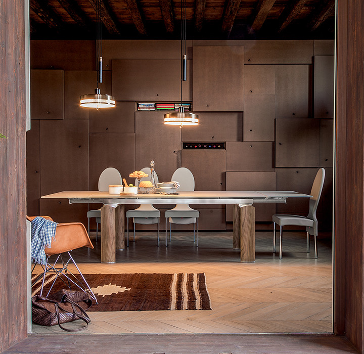 Esempio di una grande sala da pranzo aperta verso il soggiorno minimal con pareti beige, parquet chiaro e pavimento marrone