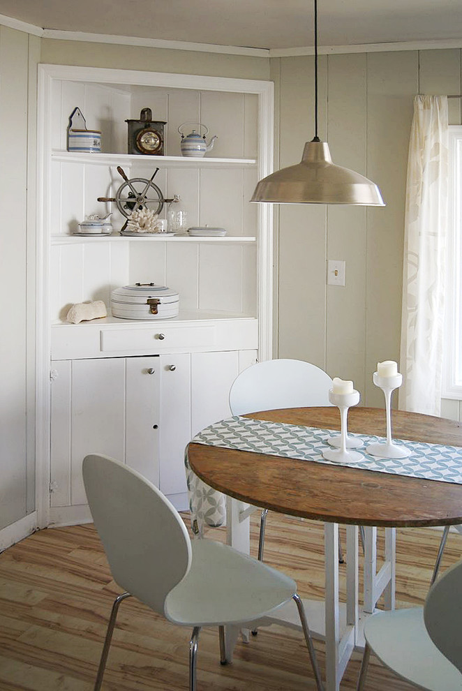 Immagine di una piccola sala da pranzo aperta verso la cucina costiera con pareti grigie