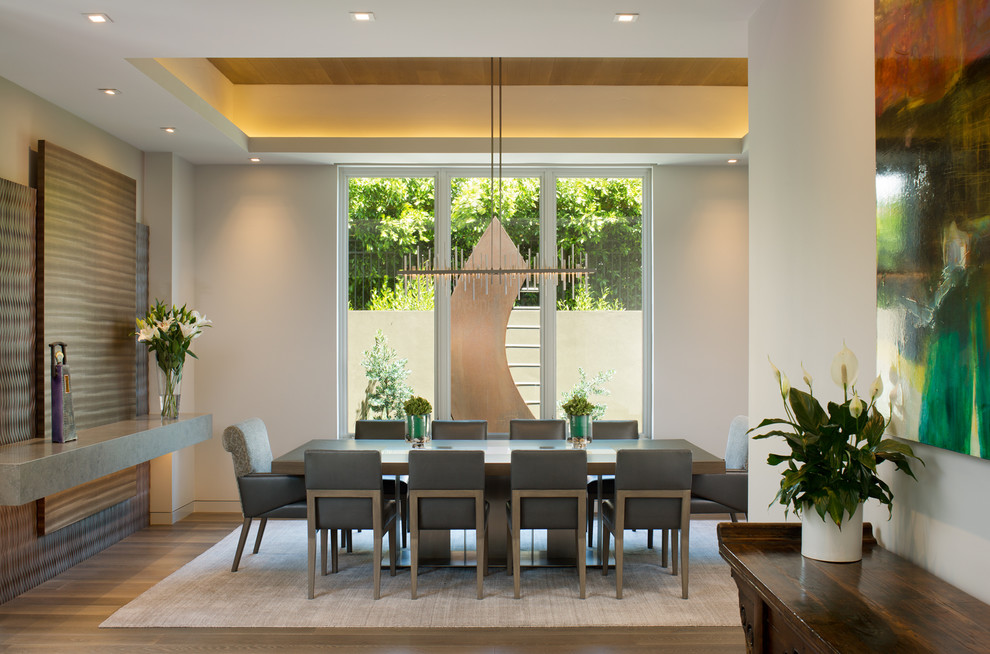Inspiration pour une salle à manger design avec un mur blanc et un sol marron.