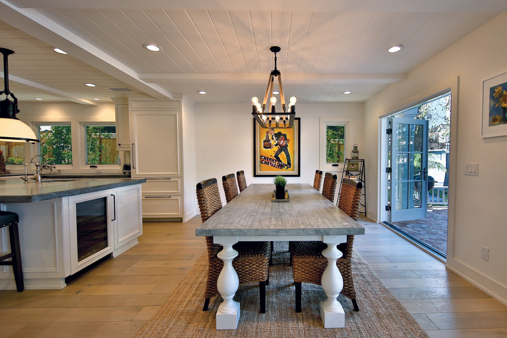 Immagine di una grande sala da pranzo aperta verso la cucina classica con pareti bianche e parquet chiaro