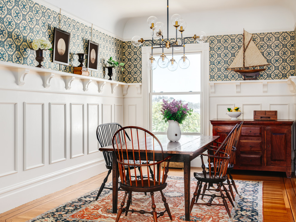 Aménagement d'une salle à manger ouverte sur la cuisine classique de taille moyenne avec un mur multicolore, un sol en bois brun et aucune cheminée.