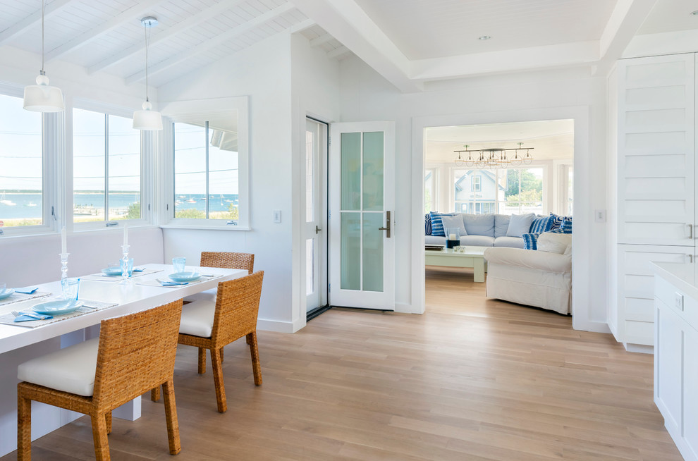 Inspiration for a coastal medium tone wood floor and beige floor dining room remodel in Boston with white walls
