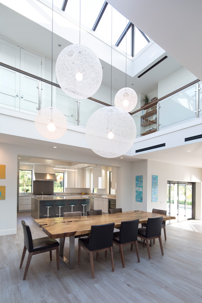 Idée de décoration pour une salle à manger design avec un mur blanc, parquet clair et un sol beige.