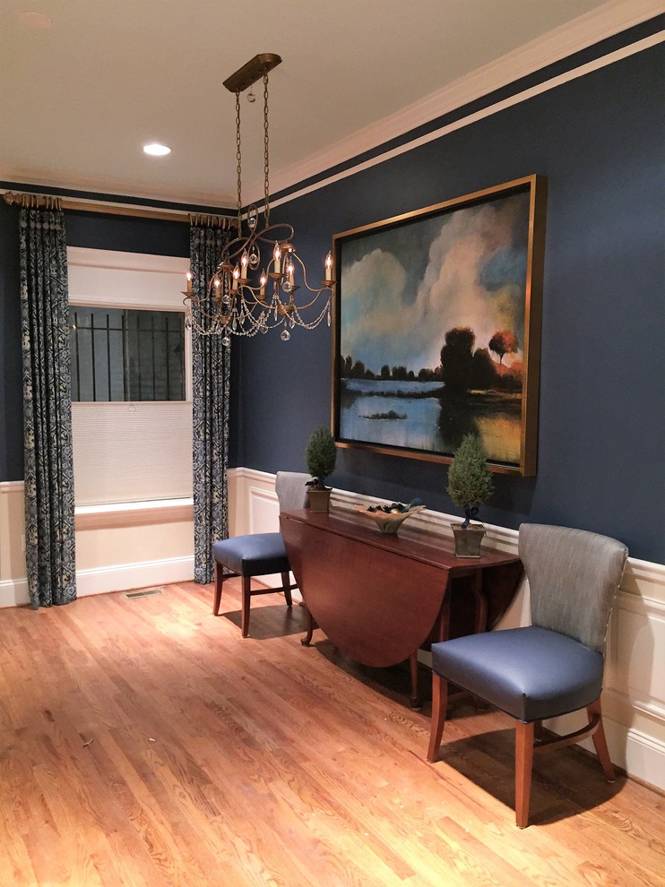 Immagine di una sala da pranzo tradizionale di medie dimensioni e chiusa con pareti blu, pavimento in legno massello medio e pavimento marrone