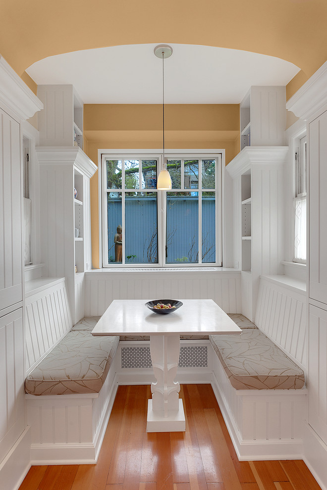Modelo de comedor de cocina tradicional renovado con suelo de madera en tonos medios y paredes beige
