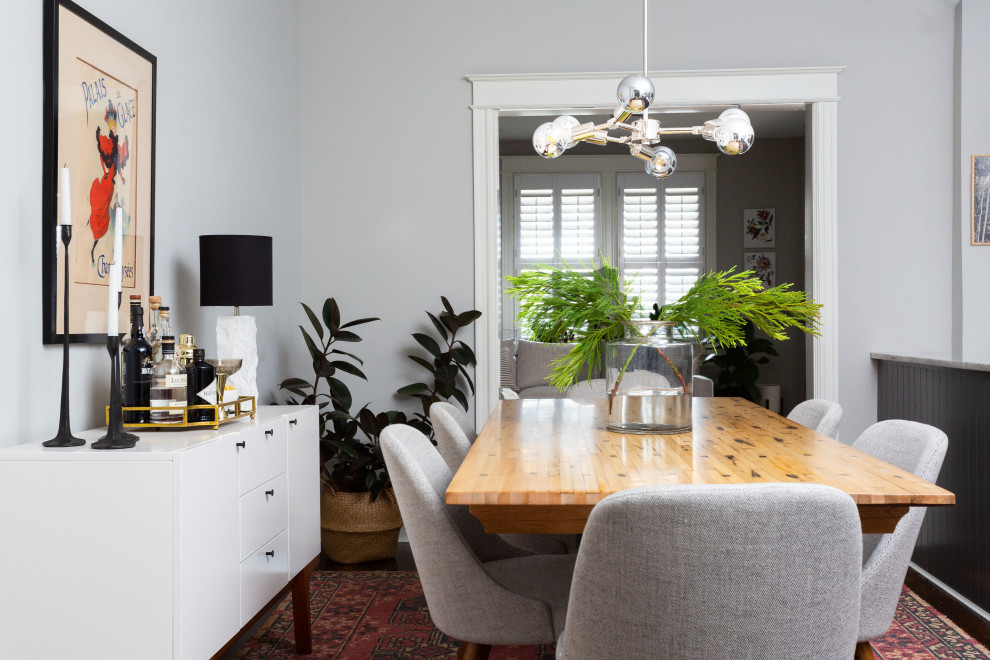 Immagine di una piccola sala da pranzo aperta verso la cucina minimalista con pareti bianche, parquet scuro, nessun camino e pavimento marrone