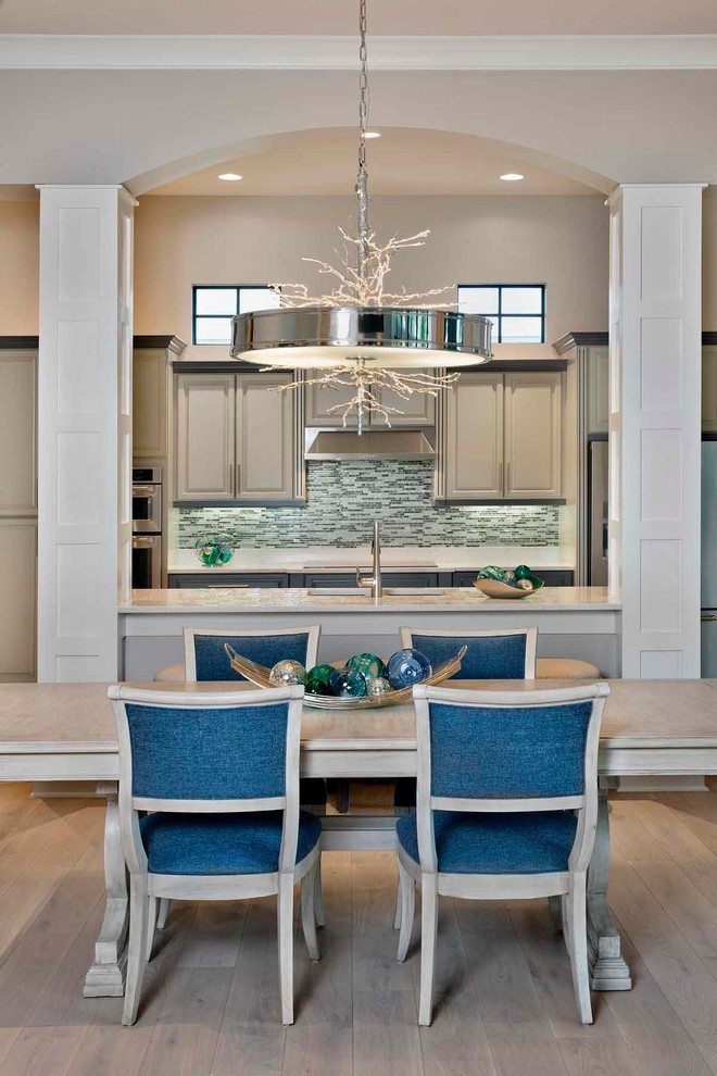 Foto di una sala da pranzo aperta verso la cucina stile marino di medie dimensioni con pareti beige, parquet chiaro e pavimento marrone