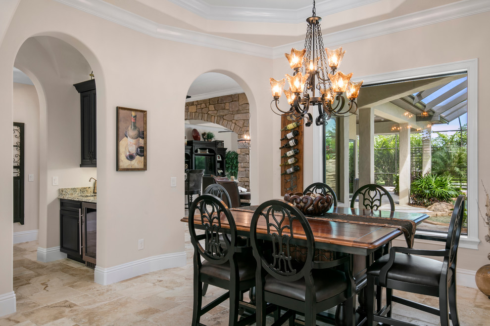 Dining room - mid-sized mediterranean travertine floor dining room idea in Orlando with white walls and no fireplace