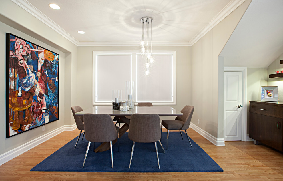 Immagine di una sala da pranzo minimal con pareti beige, pavimento in legno massello medio e nessun camino