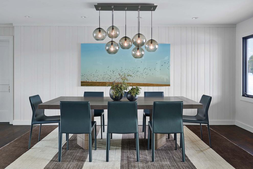 Cette image montre une salle à manger traditionnelle avec un mur blanc, parquet foncé, un sol marron et du lambris de bois.