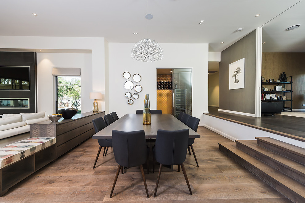 Immagine di un'ampia sala da pranzo aperta verso il soggiorno design con pareti bianche e pavimento in legno massello medio