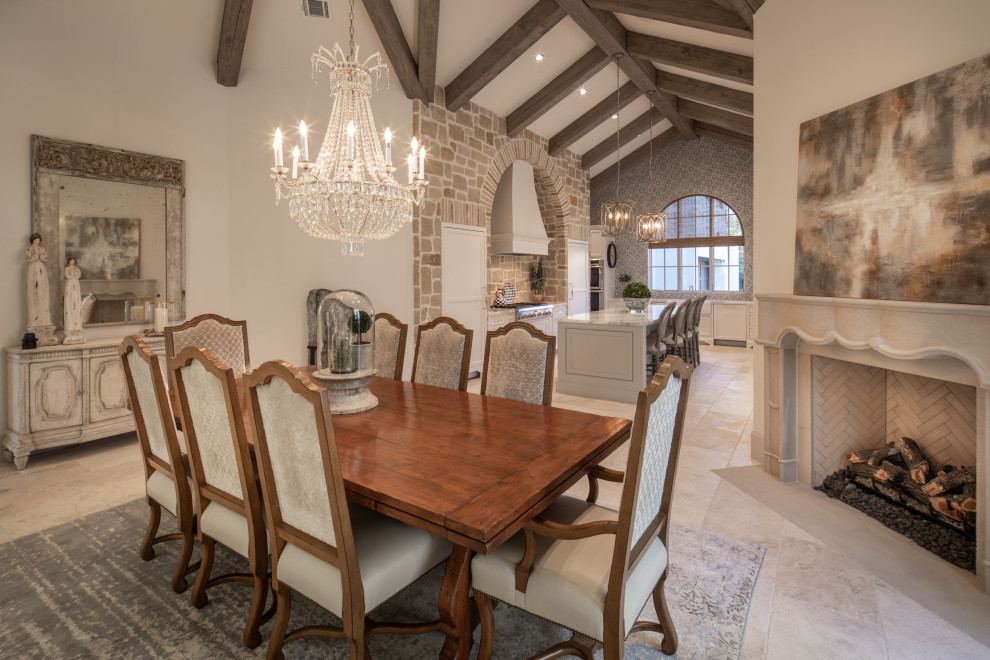 Cette photo montre une salle à manger ouverte sur la cuisine méditerranéenne avec un mur blanc, une cheminée d'angle, un sol beige, poutres apparentes et un plafond voûté.