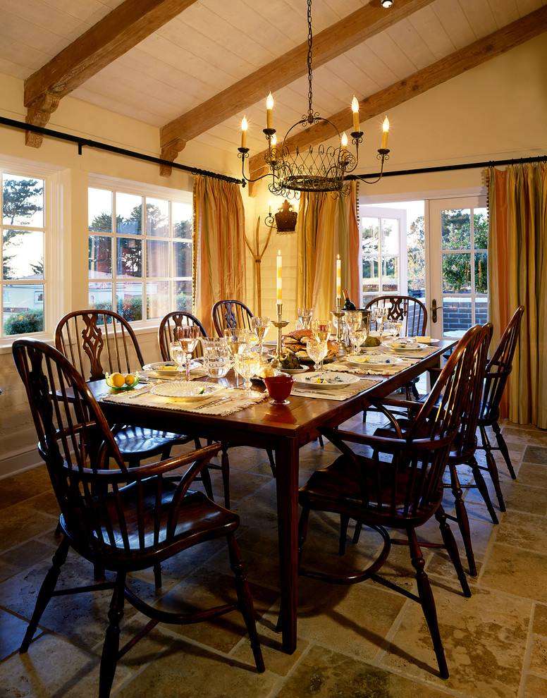 Idée de décoration pour une salle à manger ouverte sur le salon tradition avec un mur jaune et un sol en calcaire.