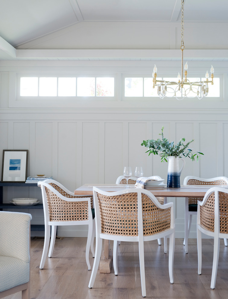 Foto di una sala da pranzo stile marino con pareti bianche, pavimento in legno massello medio e pavimento marrone