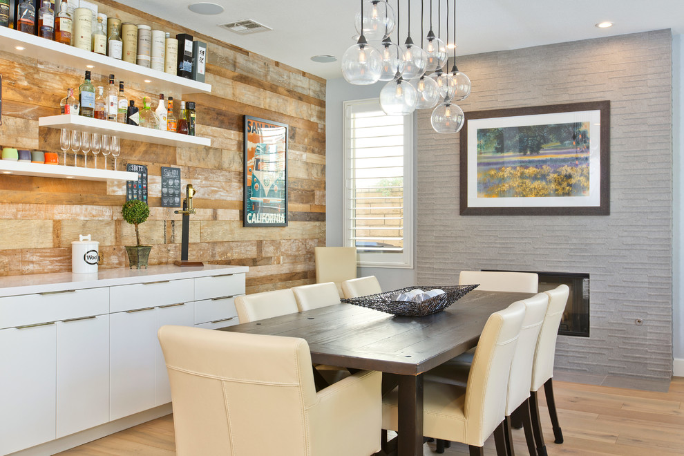 На фото: кухня-столовая среднего размера в стиле неоклассика (современная классика) с светлым паркетным полом, горизонтальным камином, бежевым полом, синими стенами и фасадом камина из плитки с