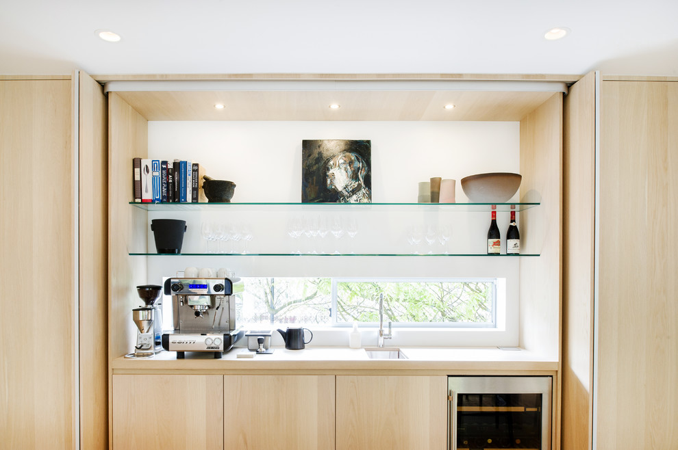 Foto di una grande sala da pranzo aperta verso la cucina minimalista con pareti bianche e parquet chiaro