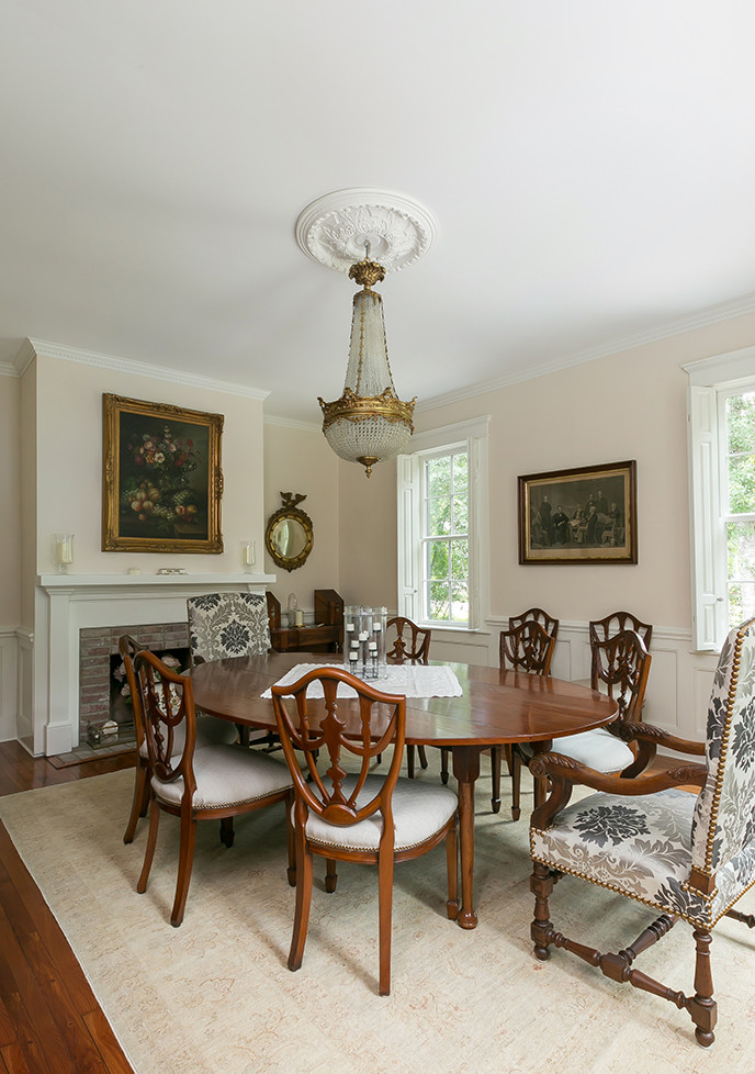 Aménagement d'une salle à manger classique fermée et de taille moyenne avec un sol en bois brun, une cheminée standard et un manteau de cheminée en plâtre.
