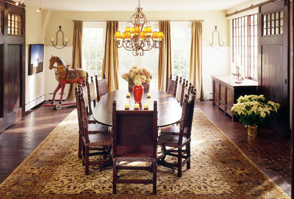 Immagine di una sala da pranzo classica con pavimento in mattoni