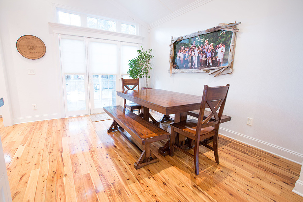 Réalisation d'une petite salle à manger ouverte sur la cuisine marine avec un mur blanc et un sol en bois brun.