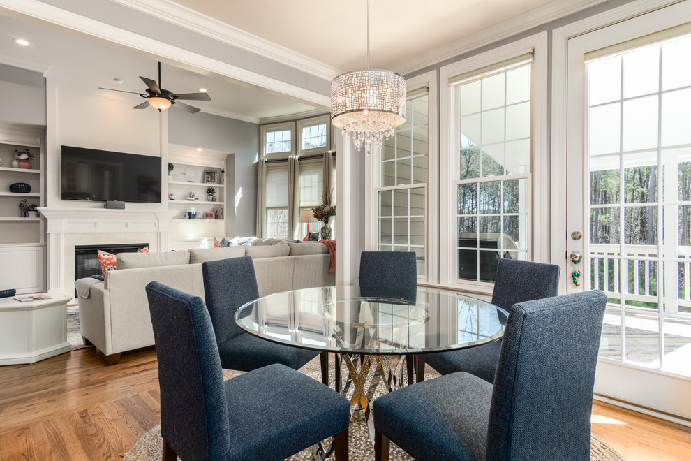 Medium sized classic open plan dining room in Raleigh with grey walls, medium hardwood flooring, a standard fireplace and a tiled fireplace surround.