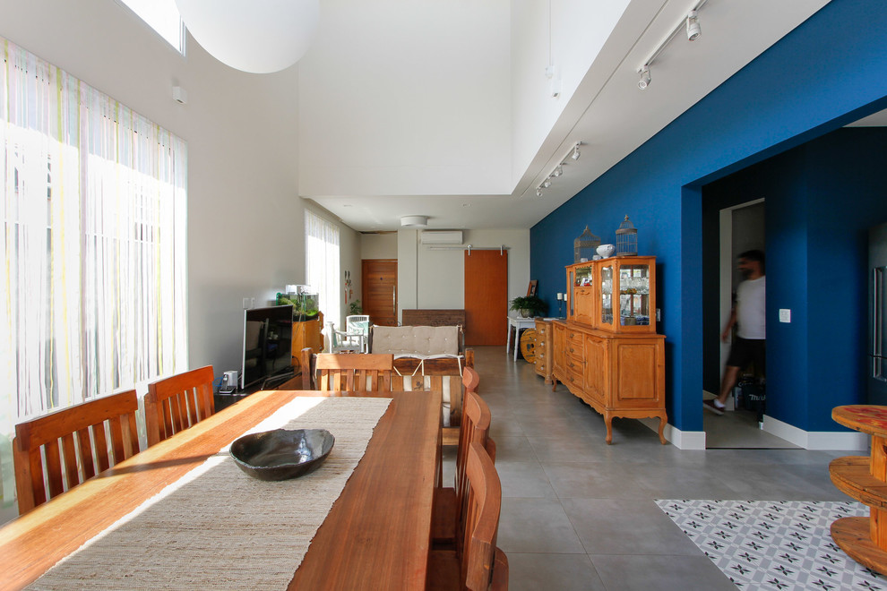 Idées déco pour une salle à manger contemporaine de taille moyenne avec un mur bleu, sol en béton ciré et un sol gris.